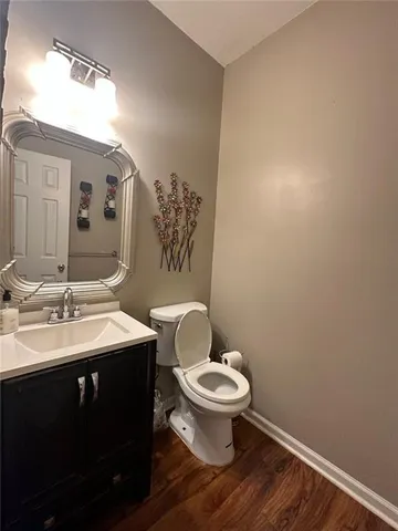 a bathroom with a granite countertop toilet sink and mirror