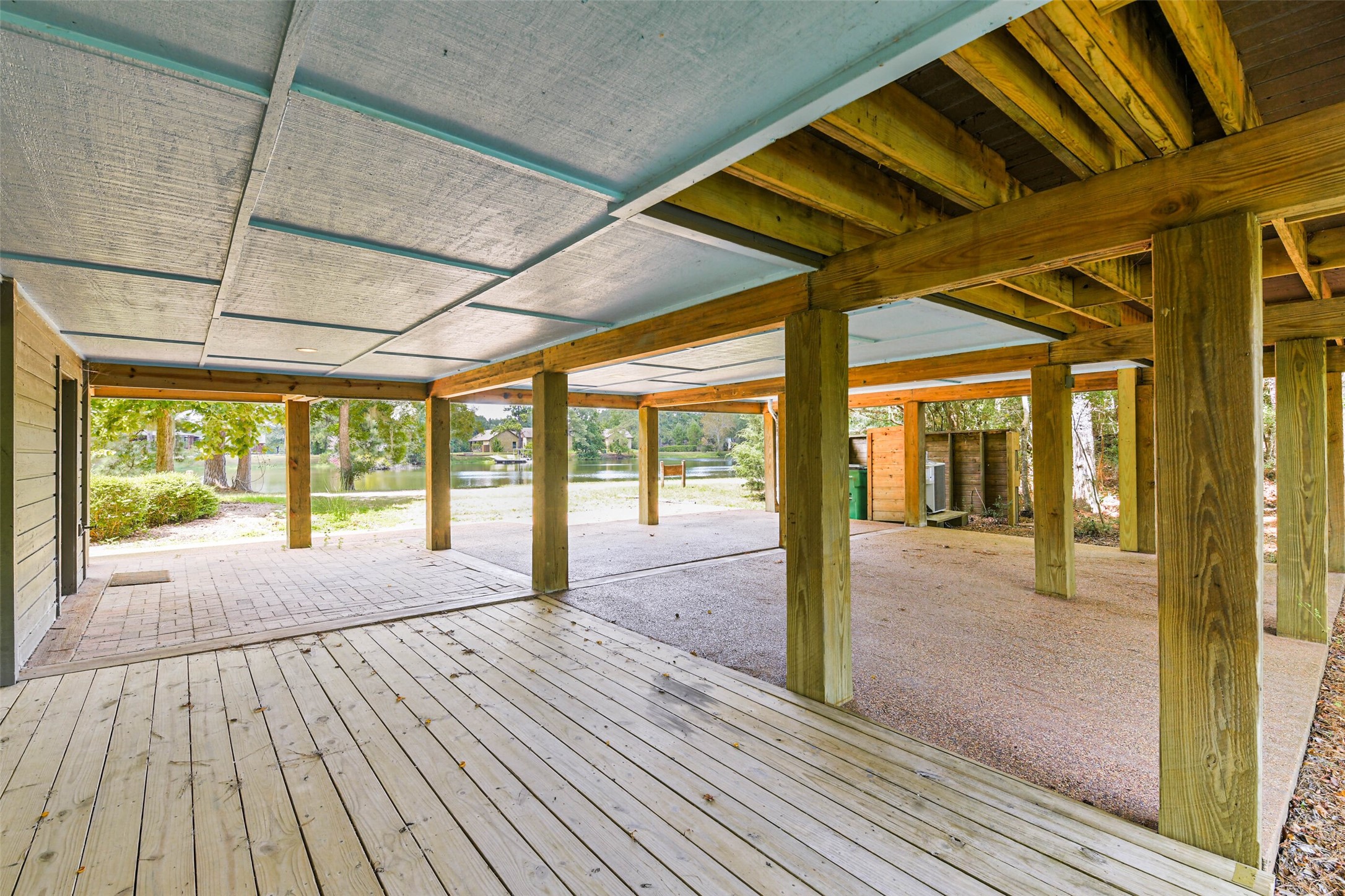 88 Raccoon Ramble Cleveland, TX 77327 - Photo 40 of 43 Spacious covered patio with sturdy wooden beams and a serene lakeside view.