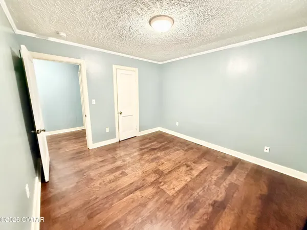 an empty room with wooden floor and entrance