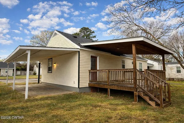 a view of a house with a yard balcony and wooden fence