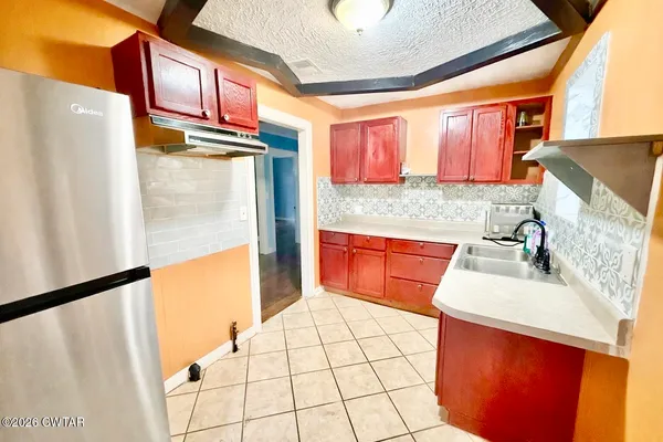 a kitchen with stainless steel appliances a sink stove and a refrigerator