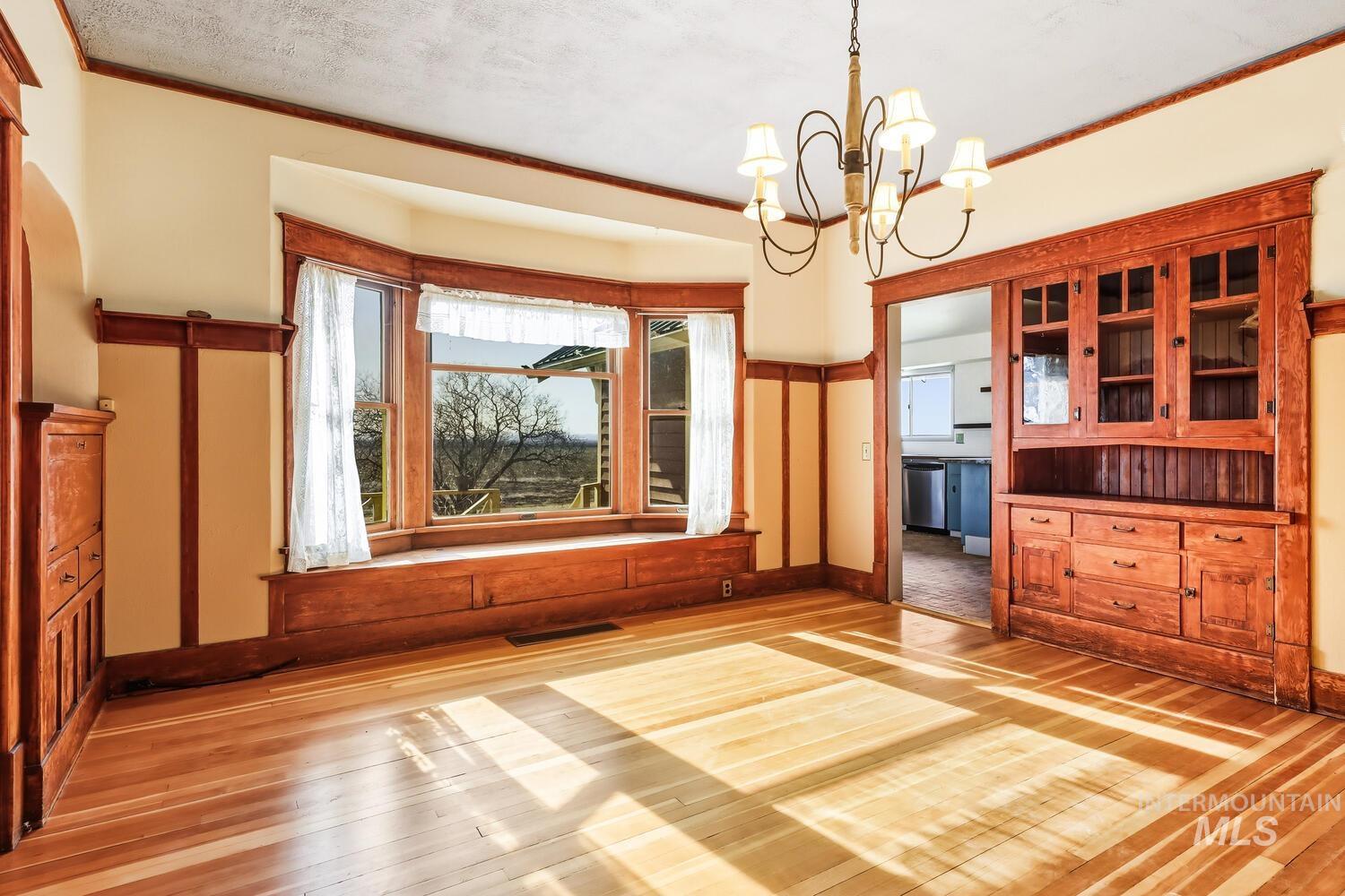 22573 Travis Road Wilder, ID 83676 - Photo 11 of 30 Unfurnished dining area with light wood finished floors and suspended lighting