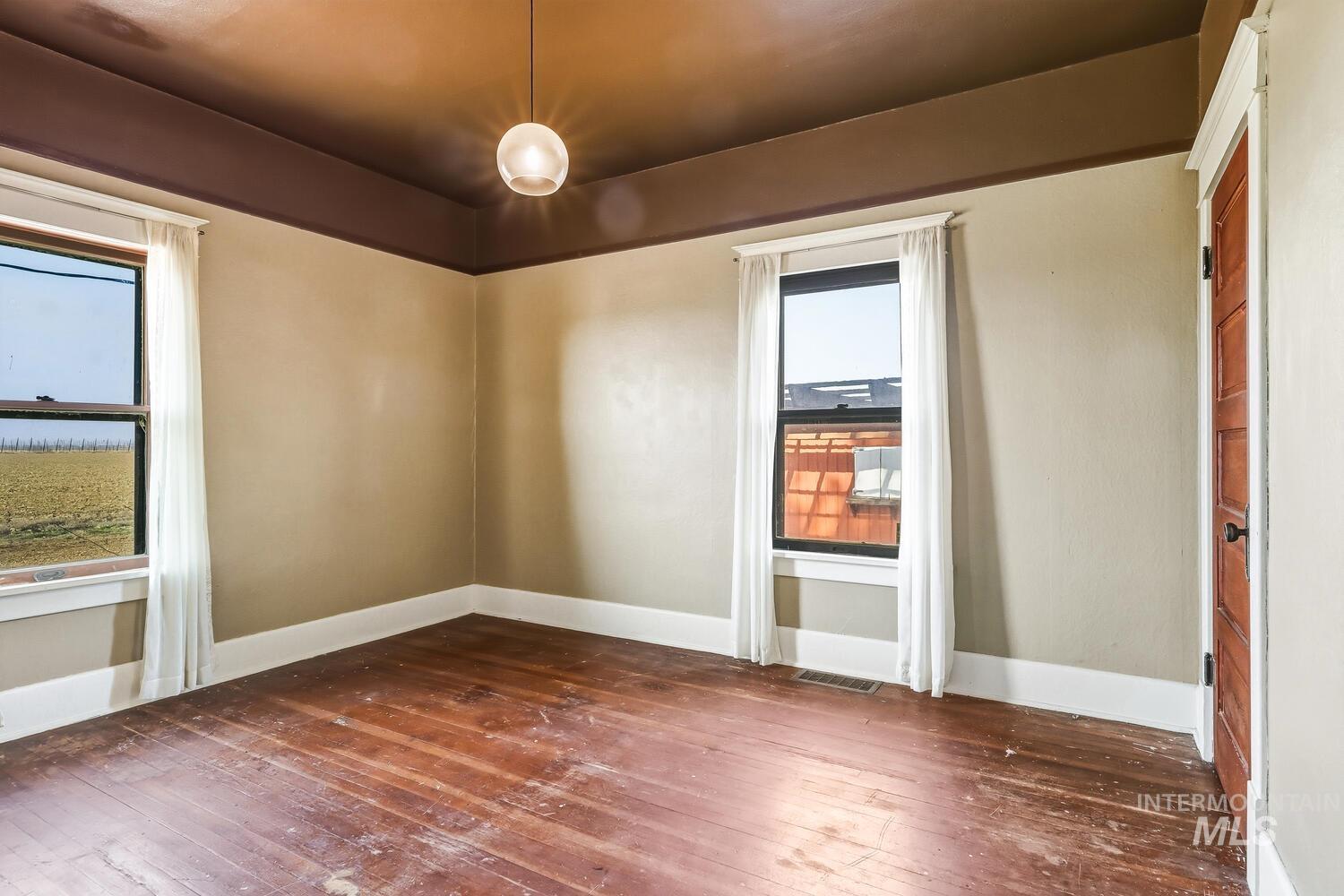 22573 Travis Road Wilder, ID 83676 - Photo 18 of 30 Empty room with dark wood-type flooring and healthy amount of natural light