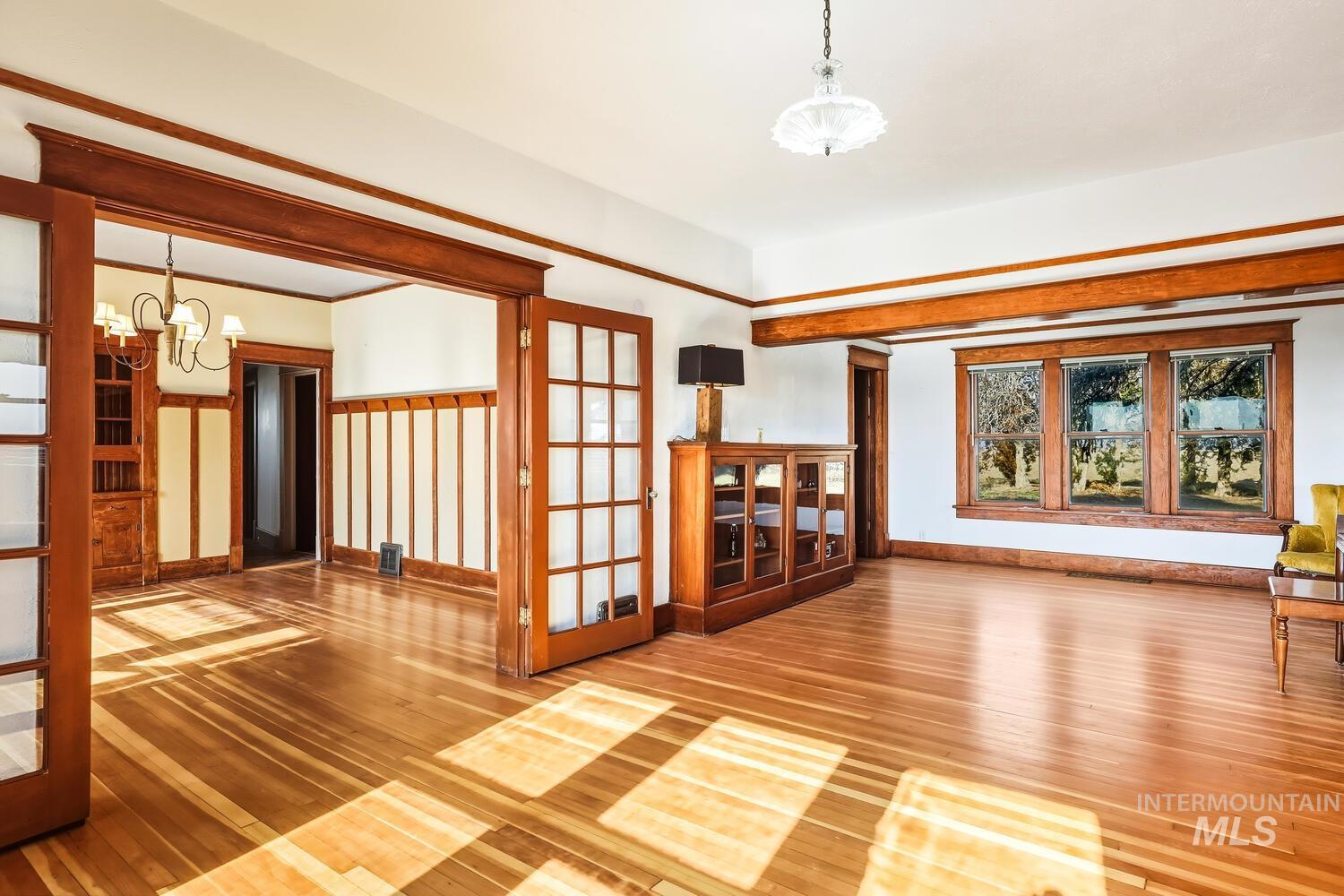 22573 Travis Road Wilder, ID 83676 - Photo 7 of 30 Unfurnished room with a chandelier, hardwood / wood-style floors, and french doors