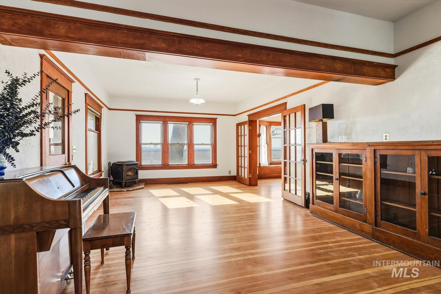 22573 Travis Road Wilder, ID 83676 - Photo 8 of 30 Unfurnished living room with french doors, light wood-style floors, and a wood stove