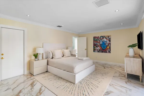 a bedroom with a large bed and a chandelier