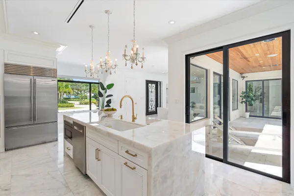 a view of living room with granite countertop furniture a chandelier and large windows