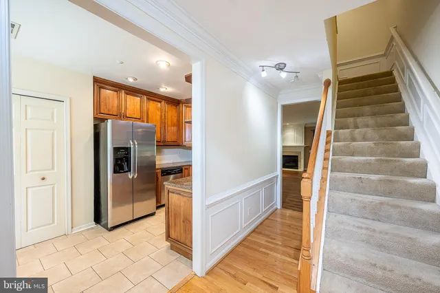 a kitchen with stainless steel appliances granite countertop a refrigerator a stove and a sink