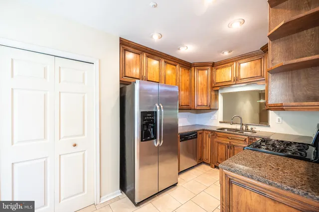 a kitchen with stainless steel appliances granite countertop a stove a sink and a refrigerator