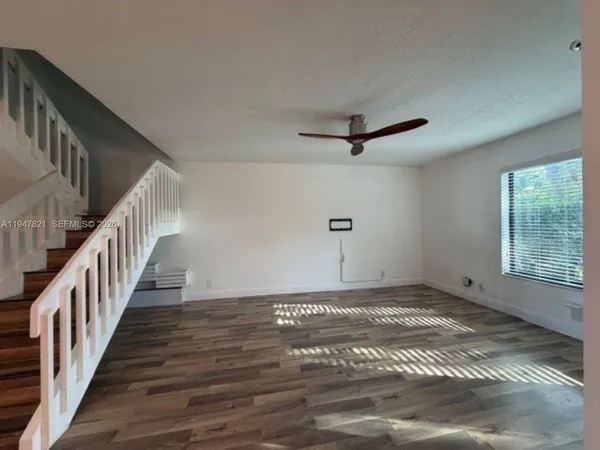a view of a livingroom with a ceiling fan and window