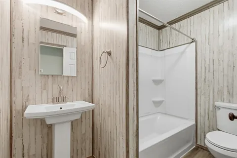 a bathroom with a sink a mirror toilet and bathtub
