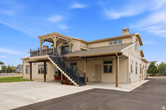 560 Aspen Road Francis, UT 84036 - Photo 9 of 59 Exterior showcasing a second-story balcony with pergola, an exterior staircase with metal railings, and a ground-level patio
