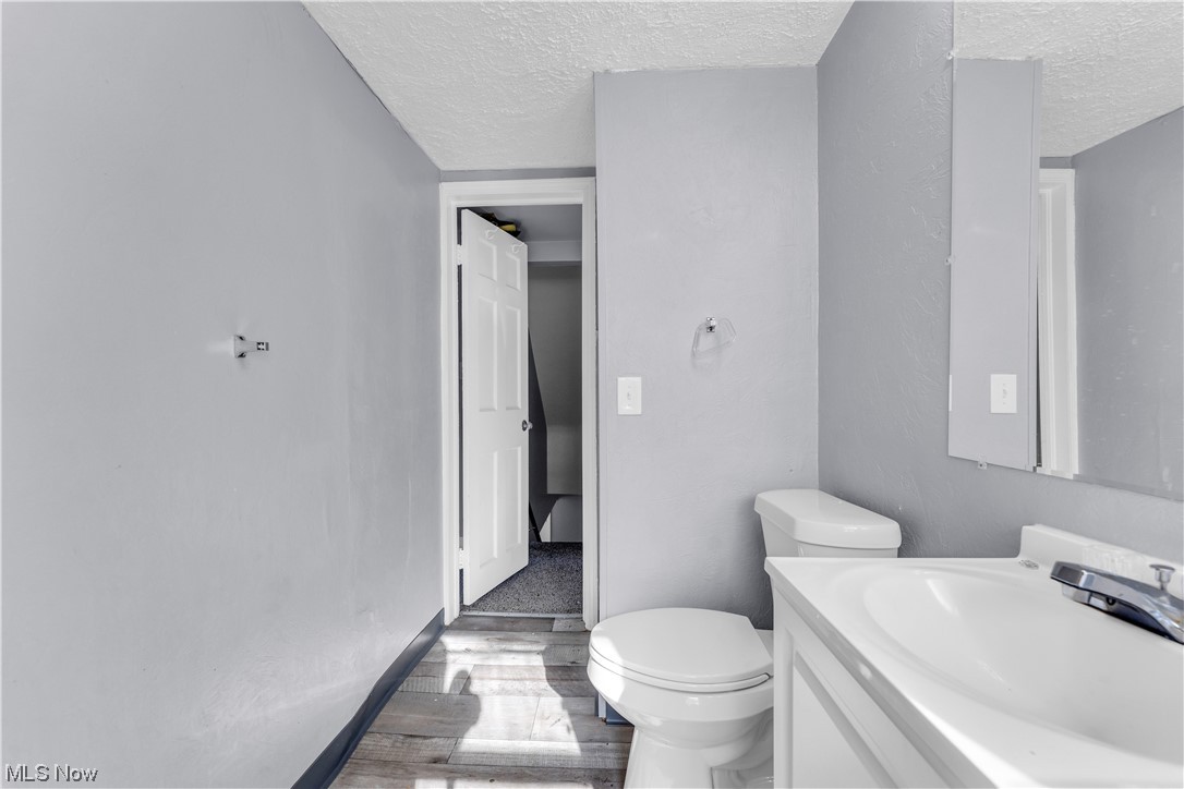 15400 Rockside Road Maple Heights, OH 44137 - Photo 24 of 31 Bathroom with toilet, a textured ceiling, and oversized vanity