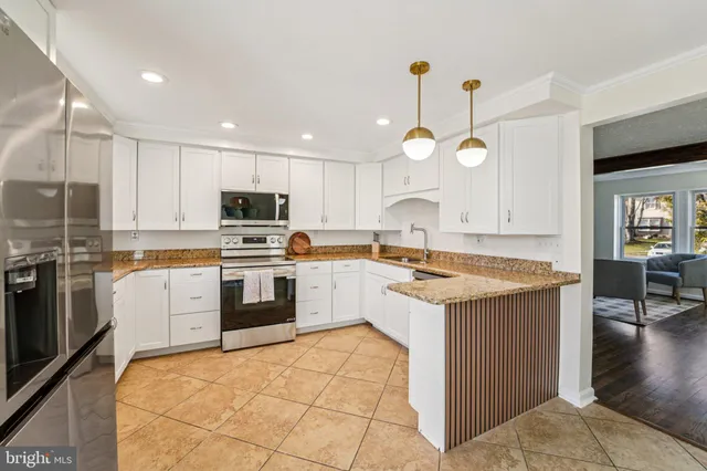 a kitchen with a dining table cabinets and stainless steel appliances