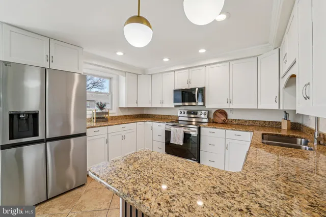 a large kitchen with granite countertop a stove oven and a sink