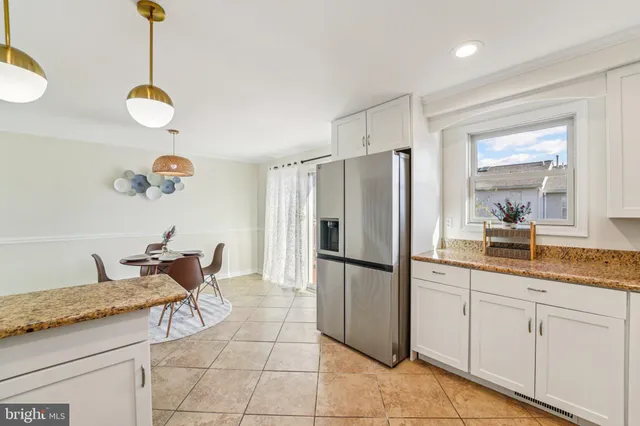 a kitchen with granite countertop a refrigerator stove top oven and sink