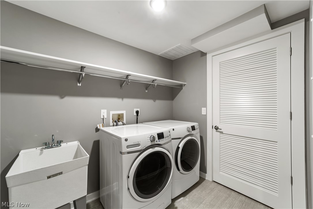 2044 Random Road, Unit 101 Cleveland, OH 44106 - Photo 24 of 44 Clothes washing area main level 2nd floor featuring sink and washing machine and dryer