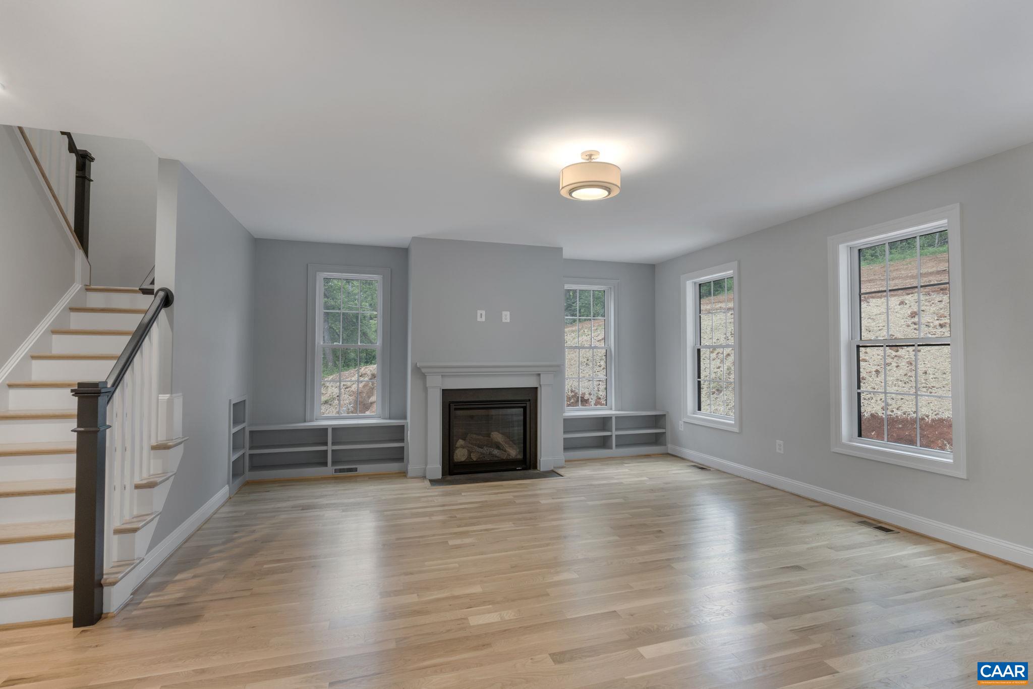 3 Lonicera Way Charlottesville, VA 22911 - Photo 13 of 31 an empty room with windows a fireplace and wooden floor