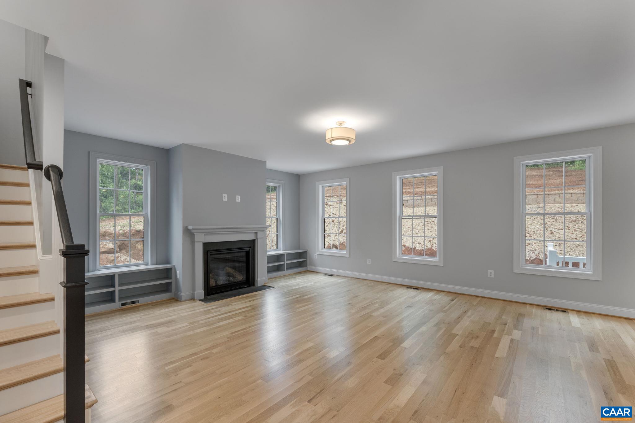 3 Lonicera Way Charlottesville, VA 22911 - Photo 10 of 31 an empty room with windows a fireplace and wooden floor