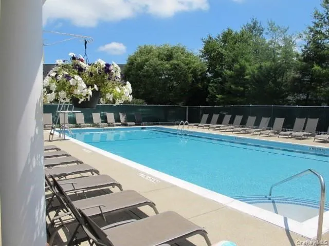 a view of swimming pool with seating area and trees