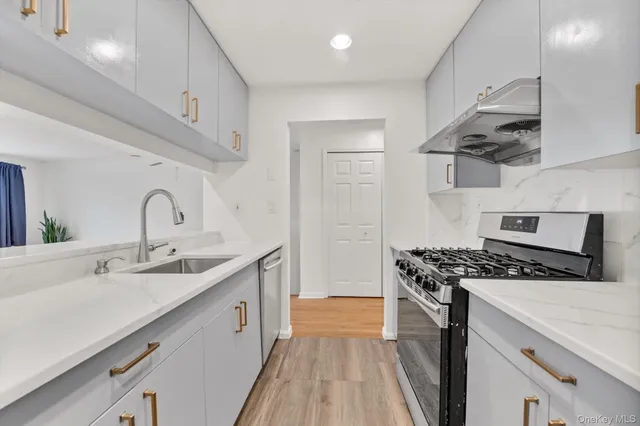 a kitchen with stainless steel appliances a sink stove and cabinets