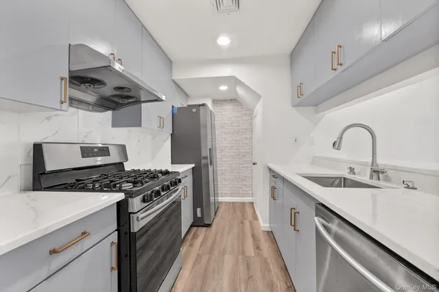 a kitchen with stainless steel appliances a sink stove and refrigerator