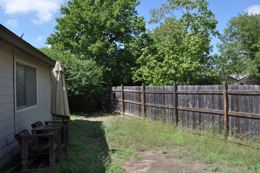 5916 A Cherry Loop Austin, TX 78745 - Photo 11 of 12 A private backyard oasis with a tall wood fence, offering secluded outdoor living.
