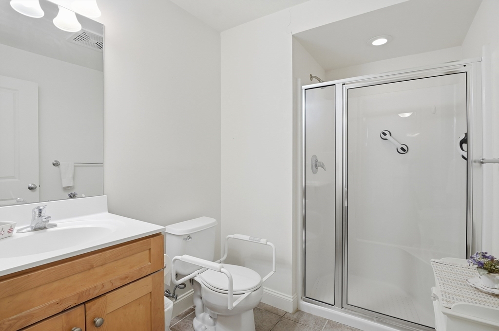 1818 Main Street, Unit 204 Holden, MA 01522 - Photo 14 of 30 a bathroom with a shower sink vanity mirror and toilet