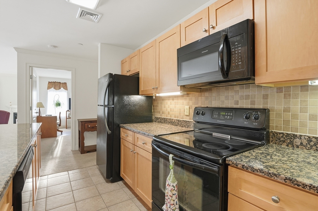 1818 Main Street, Unit 204 Holden, MA 01522 - Photo 10 of 30 a kitchen with stainless steel appliances granite countertop a stove microwave and refrigerator