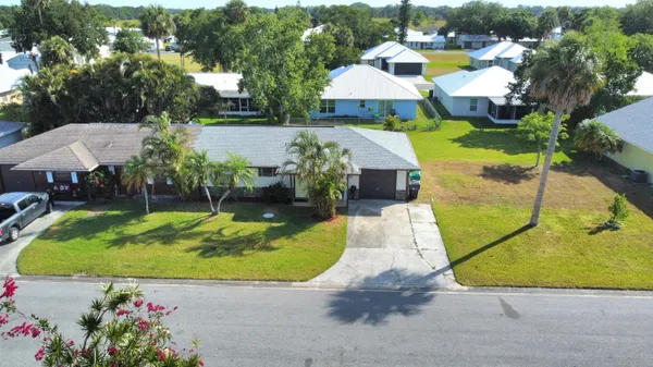 an aerial view of a house with swimming pool and large trees