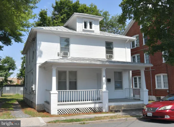 a view of a house with a yard balcony and wooden fence