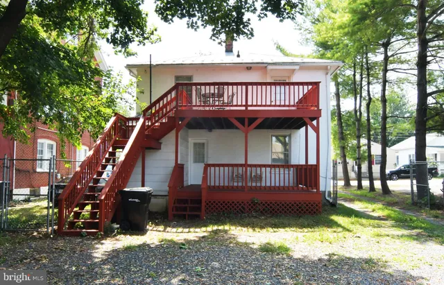a view of a house with a yard and wooden fence