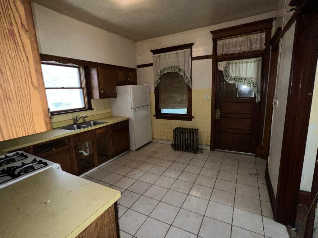 7348 South Sangamon Street Chicago, IL 60621 - Photo 16 of 29 a kitchen with stainless steel appliances granite countertop a stove a sink and a refrigerator
