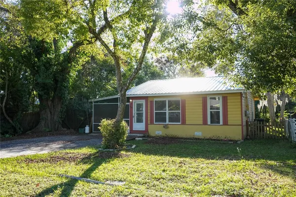 a view of a house with backyard and sitting area