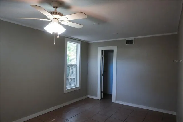 an empty room with windows and fan