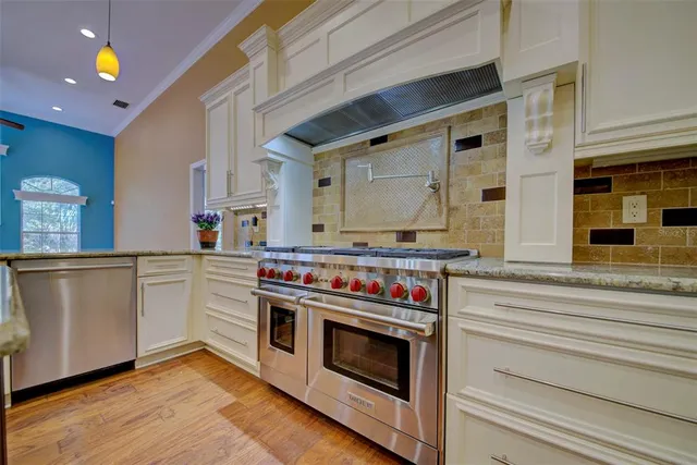 a view of a hallway to an empty room with wooden floor and a window
