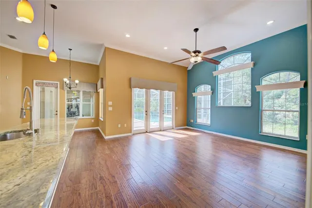 a view of a livingroom with a furniture wooden floor and a ceiling fan