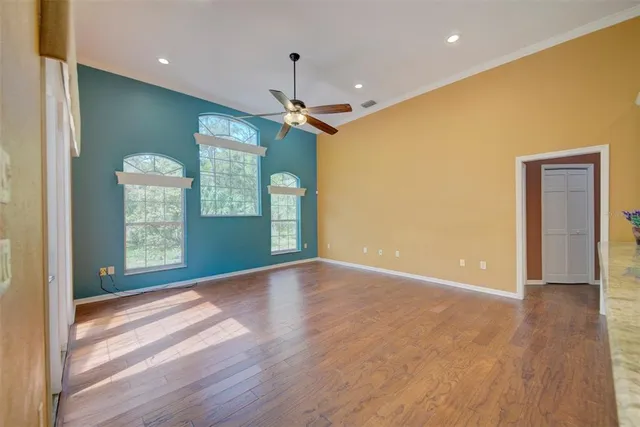 a front view of a house with a garden and trees