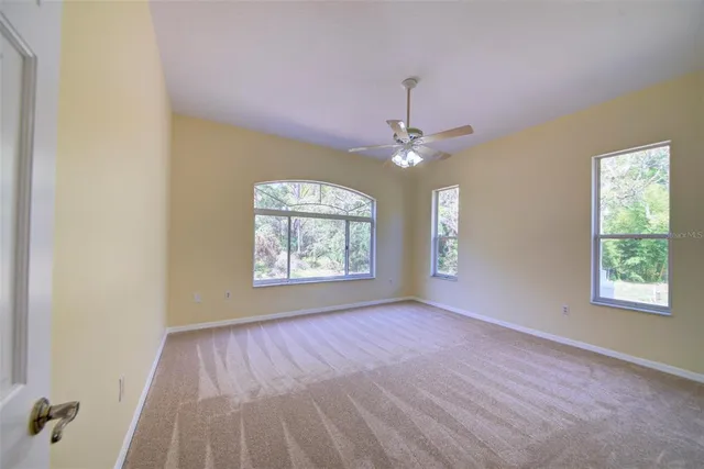 a view of a hallway with a couch and a dining table next to a window