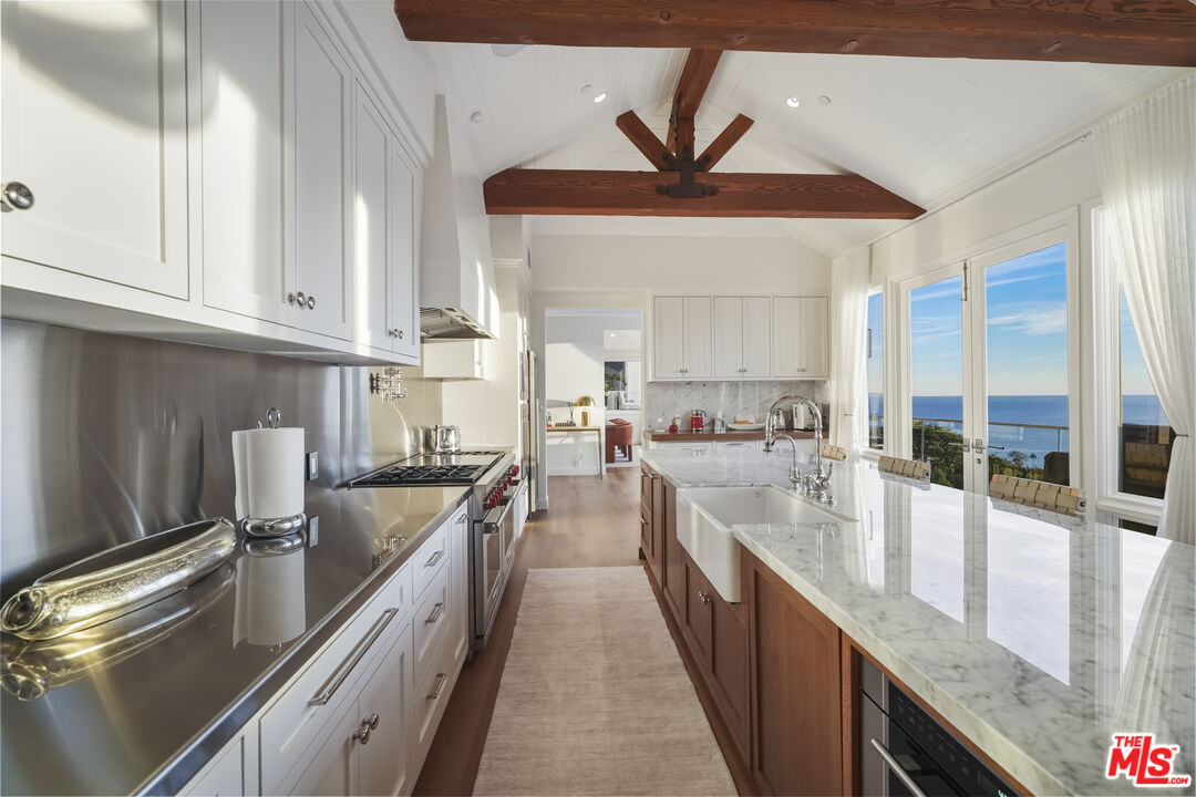 3140 Sweetwater Mesa Road Malibu, CA 90265 - Photo 16 of 71 a large kitchen with kitchen island a large counter space a sink and appliances