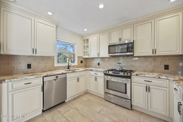 a kitchen with white cabinets stainless steel appliances and sink