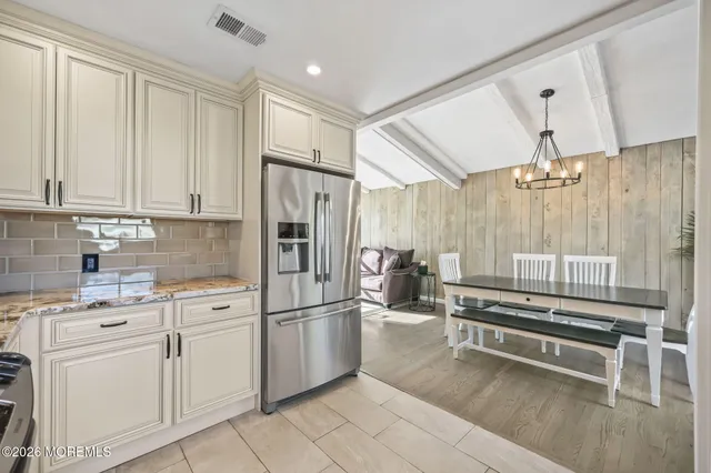a kitchen with white cabinets and refrigerator