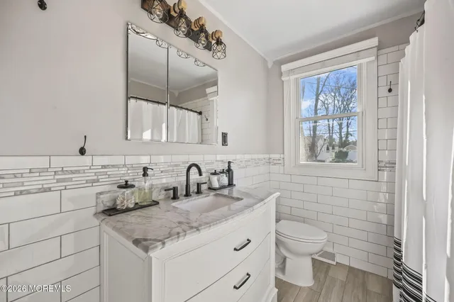 a bathroom with a toilet sink and mirror