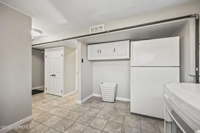 a view of kitchen with refrigerator and cabinet