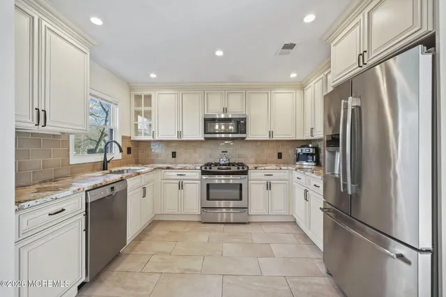 a kitchen with stainless steel appliances granite countertop a refrigerator sink and stove