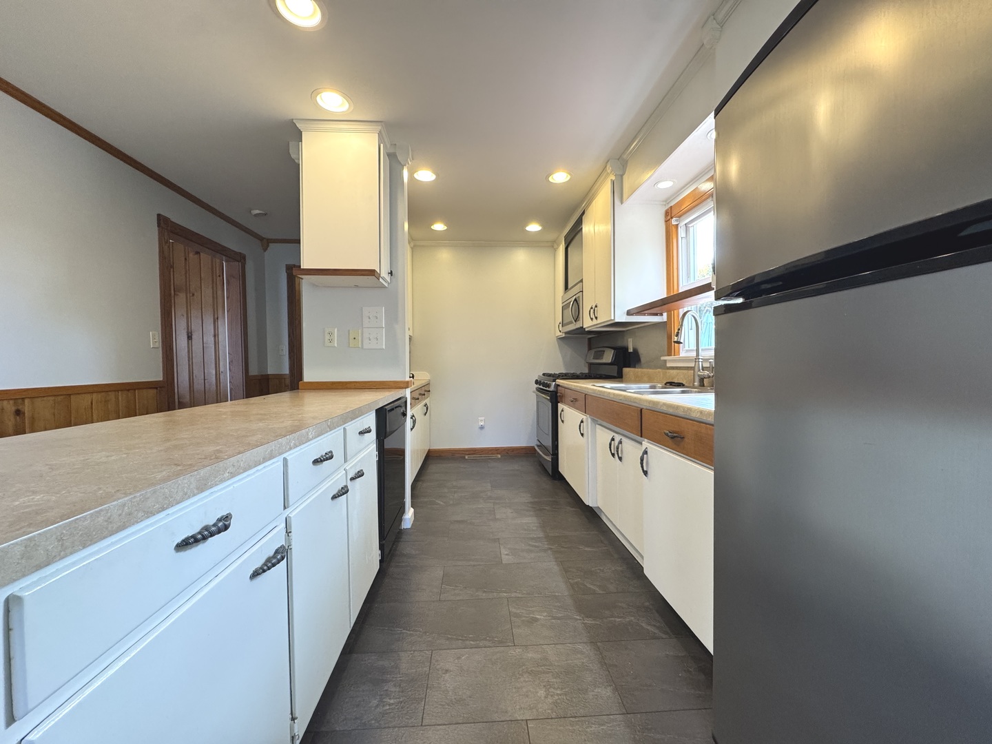 3288 South Hieland Road St. Anne, IL 60964 - Photo 11 of 45 a large white kitchen with a large counter top a stove a sink and a refrigerator