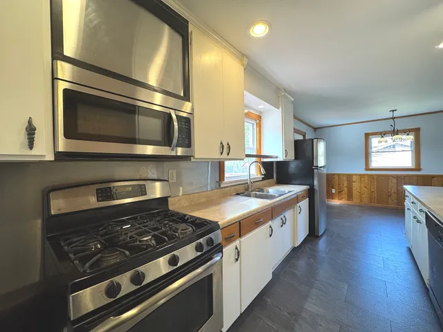 a kitchen with stainless steel appliances granite countertop a stove and a sink
