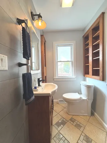a bathroom with a toilet sink and mirror