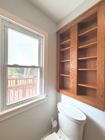 a bathroom with a toilet a sink and a window