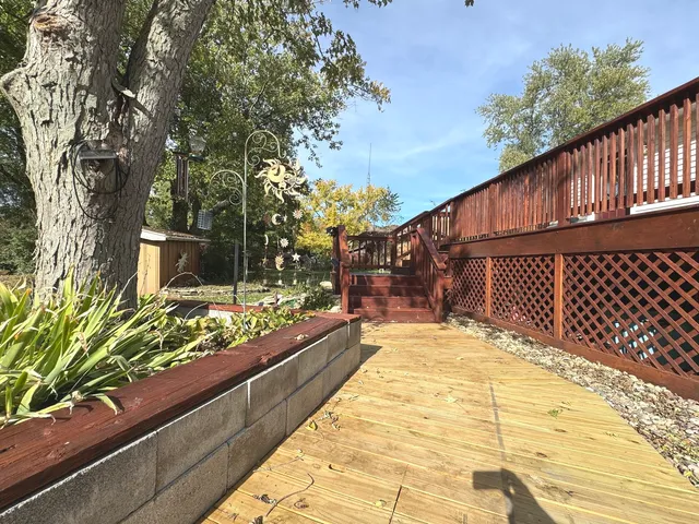 a view of a patio with couches table and chairs with wooden floor and fence